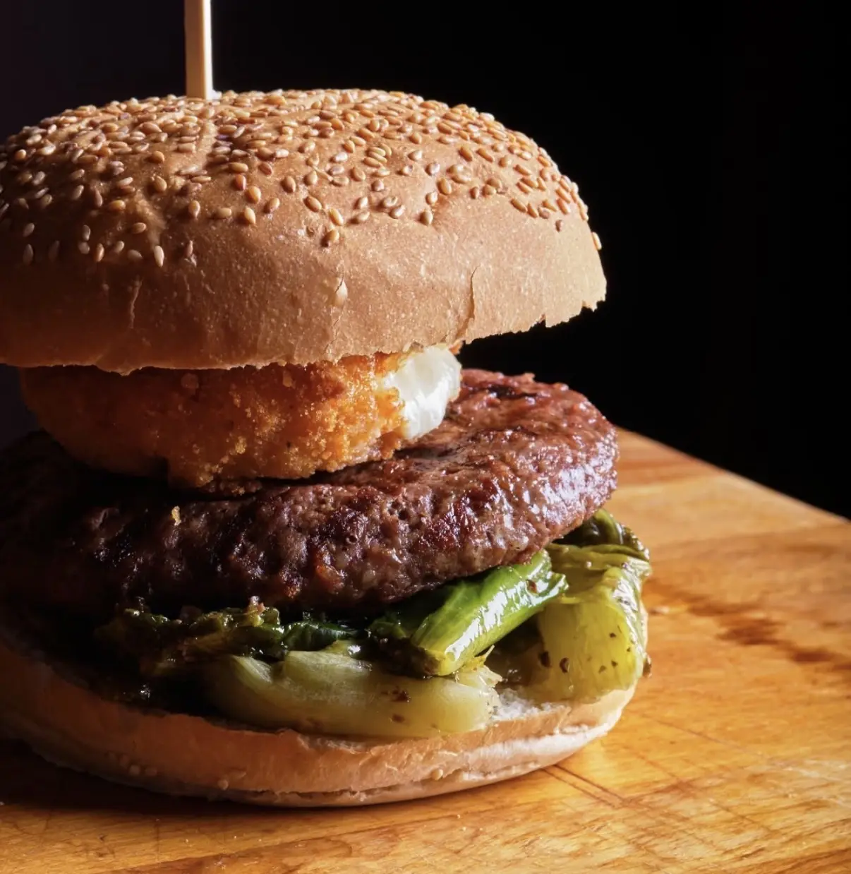 Panino con hamburger, cotoletta e friarielli su tagliere