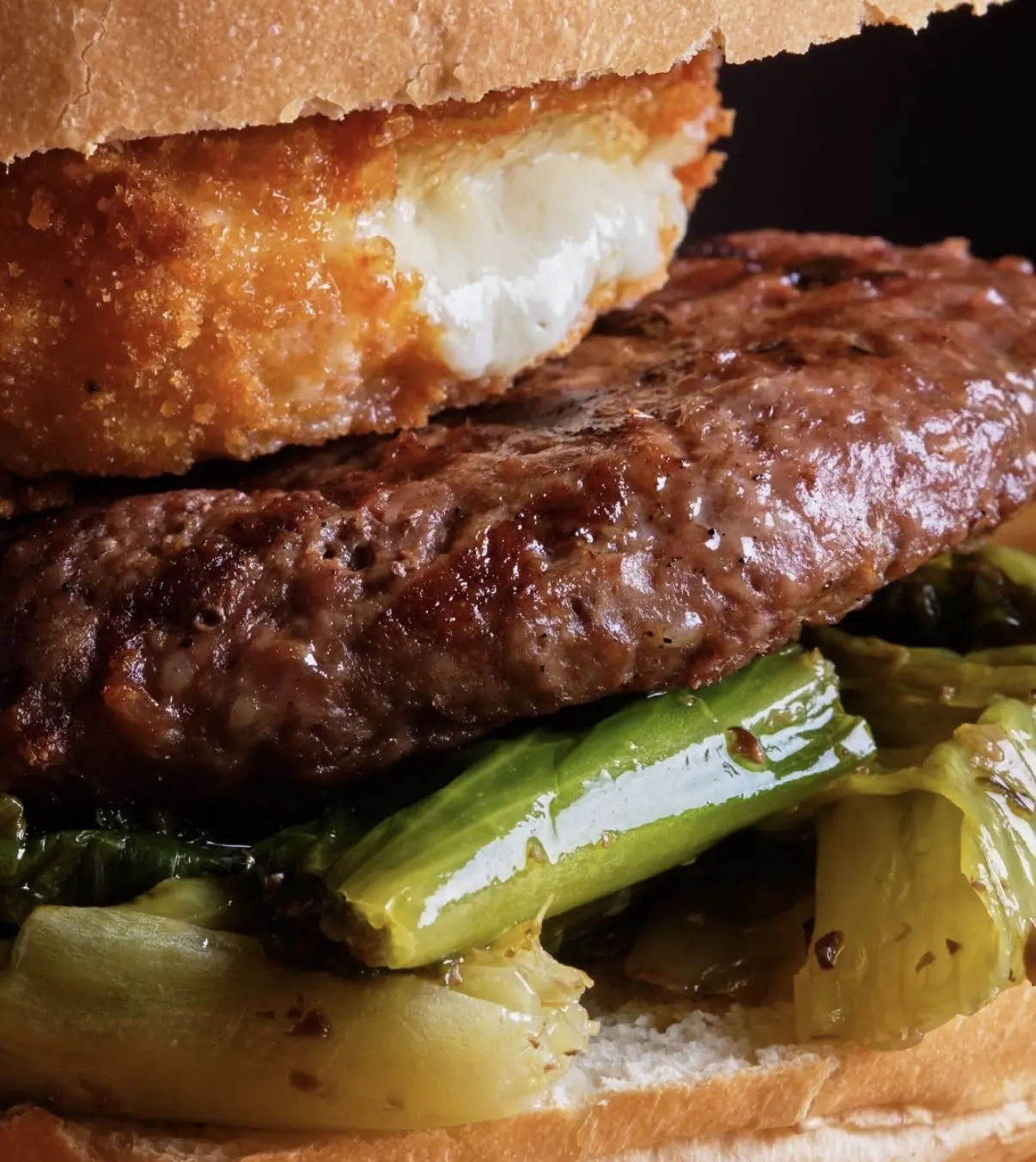 Dettaglio del panino: hamburger, cotoletta filante e friarielli