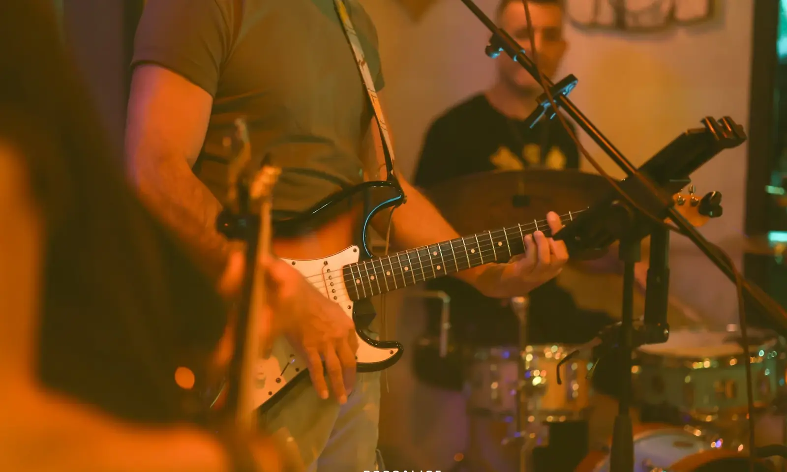 Un chitarrista e un batterista suonano durante una serata live